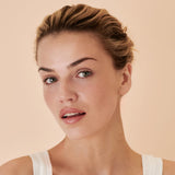 Woman with styled hair against a beige background